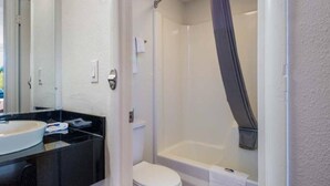 Une salle de bain avec des toilettes, un lavabo et une douche.