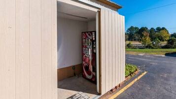 A building with a door open, revealing a vending machine inside.