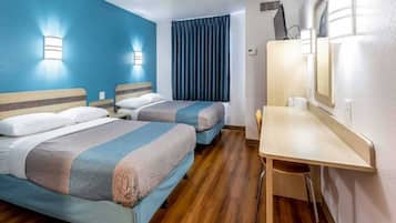 A hotel room with two beds, a desk, and a mirror.