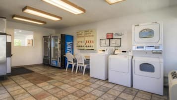 Una sala de lavandería con lavadoras, secadoras y un quiosco de autoservicio.