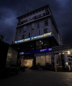 A building with multiple signs for Sri Utham Suites and Radiant Karel apartments. - Sri Utham Suites (Bengaluru)