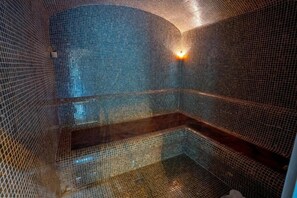 A room with a tiled wall, a light fixture, and a staircase.