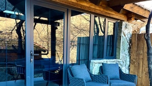 A covered patio area with sliding glass doors, two chairs, and a table.