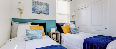 A bedroom with two beds, each with a blue and white bedspread, and a globe on a nightstand.