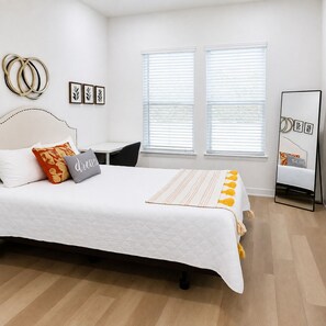 A neatly arranged bedroom with a bed, bedside tables, and a mirror. - Near Lake Texoma 1BR Kingbed Pool I GYM (Sherman)