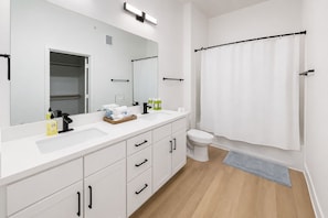 A modern bathroom with a white sink, mirror, and toilet. - Near Lake Texoma 1BR Kingbed Pool I GYM (Sherman)