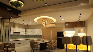 Una cocina moderna con una isla central, iluminación empotrada y una zona de comedor con sillas.