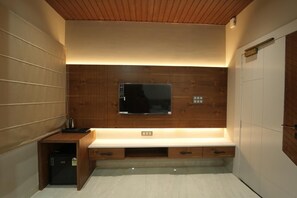 A modern kitchen with a built-in microwave, a small refrigerator, and a countertop with drawers.