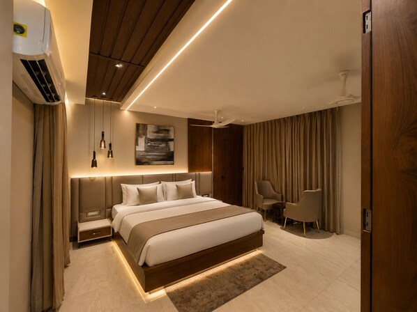 Un dormitorio moderno con una cama grande, mesitas de noche, un escritorio y una silla.