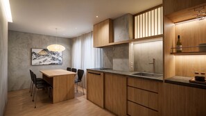 Una cucina moderna con mobili in legno, un lavello in acciaio inossidabile e un'area pranzo con tavolo e sedie.