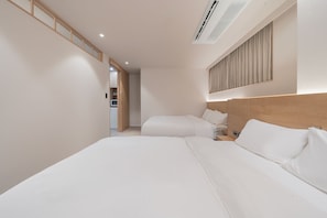 Habitació d'hotel amb un llit gran, una taula de nit, un armari i vistes al passadís.