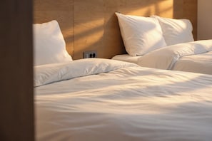 A hotel room with two beds, each with white bedding and pillows, and a wooden headboard. - The Gamro Gangnam (Seoul)