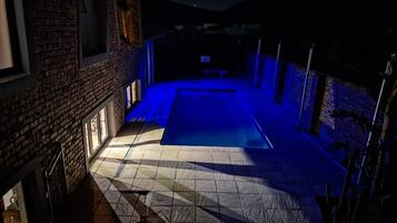 Un área de piscina con suelo de baldosas y pared de ladrillo.