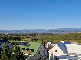 Zona residencial con casas, paneles solares y un campo verde.