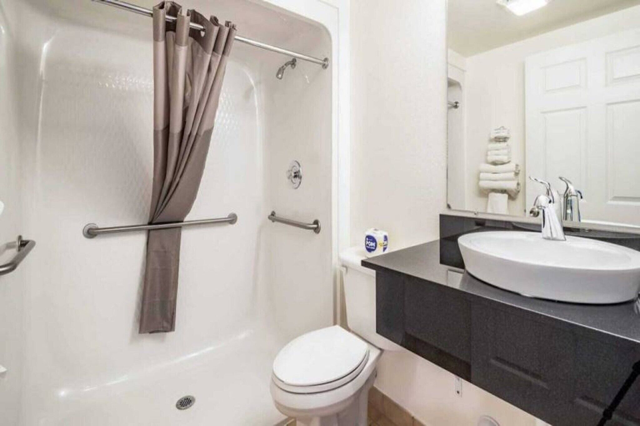 Un baño con bañera, inodoro, lavamanos y cortina de ducha.