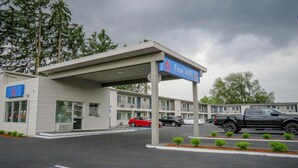 Un motel con zona de estacionamiento techada, un letrero que indica WiFi gratis y un edificio con el número 6.