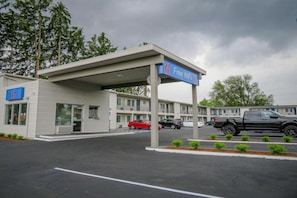 Un motel con área de estacionamiento techada, un cartel que indica WiFi gratis y un letrero con el número 6.