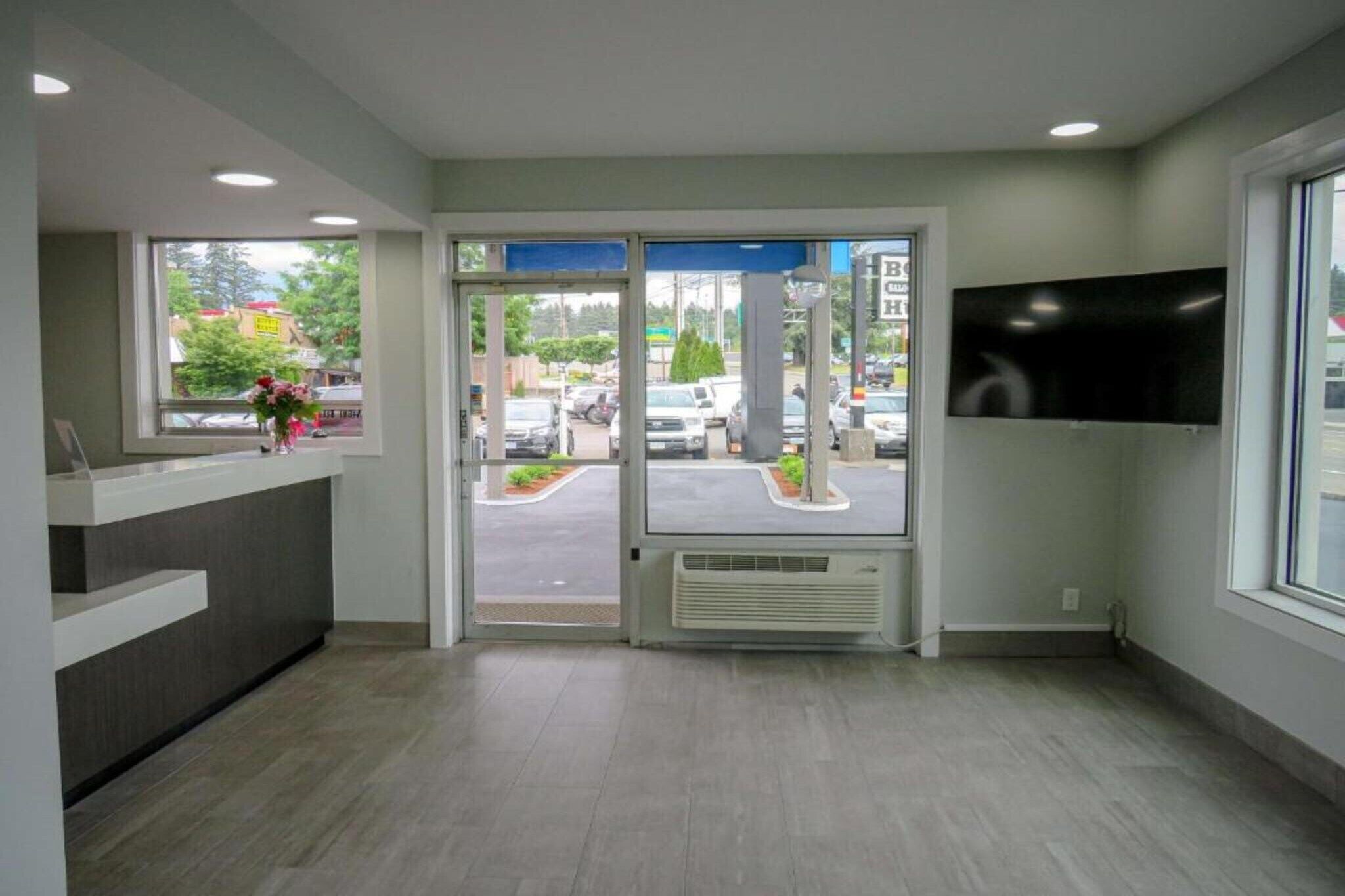 A reception area with a desk, a large window, and a view of the street outside.