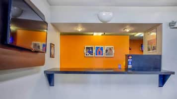 A reception area with a counter, framed pictures on the wall, and a Visa payment terminal.