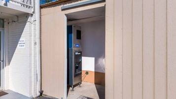 A building entrance with a door leading to a room containing an ICE machine.