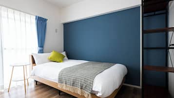 A modern bedroom with a bed, a small table, and a wardrobe.