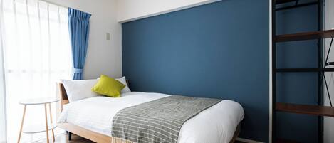 A modern bedroom with a bed, a small table, and a wardrobe.