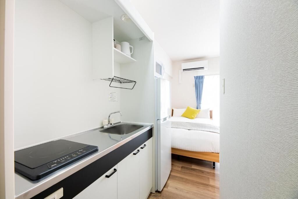 A compact kitchenette with a built-in stove, a sink, and a countertop.
