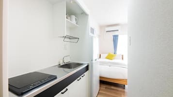 A compact kitchenette with a built-in stove, a sink, and a countertop.