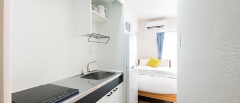 Uma cozinha compacta equipada com fogão, pia e bancada.
