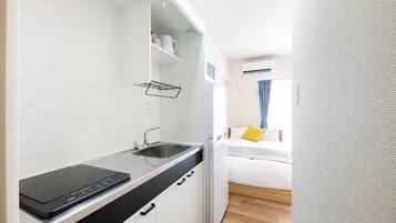 A compact kitchenette with a built-in stove, a sink, and a small countertop.