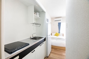 A compact kitchenette with a built-in stove, a sink, and a small countertop. - Central Heights (Fukuoka City Chuoku Watanabedori)