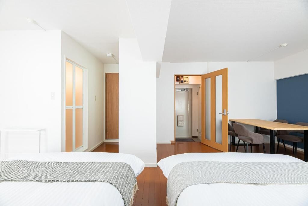 Une chambre d’hôtel avec deux lits, un bureau et une chaise.