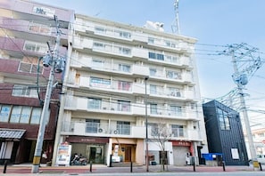 A multi-story residential building with balconies, a vending machine, and a storefront. - Central Heights (Fukuoka City Chuoku Watanabedori)