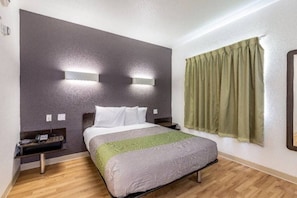 A hotel room with a bed, bedside tables, a telephone, a green throw blanket, and a window with curtains. - 1 Queen Bed | Non-Smoking, Kitchen (Orange)