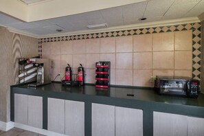 A reception desk with a tiled wall, a coffee machine, and a microwave. - 1 King Bed | Non-Smoking (Grand Prairie)