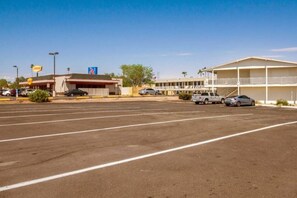 A parking lot with a motel and a gas station in the background.