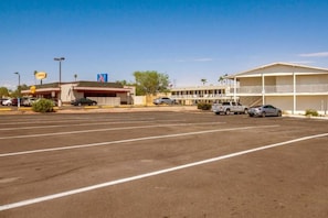 A parking lot with a motel and a gas station in the background. - 2 Full Beds|Micfridge| Smoking (Youngtown)