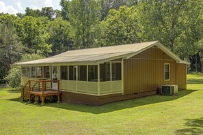 A single-story wooden cabin with a porch, a small deck, and an air conditioning unit. - Centrally Located Nature Escape in Trenton (Trenton)
