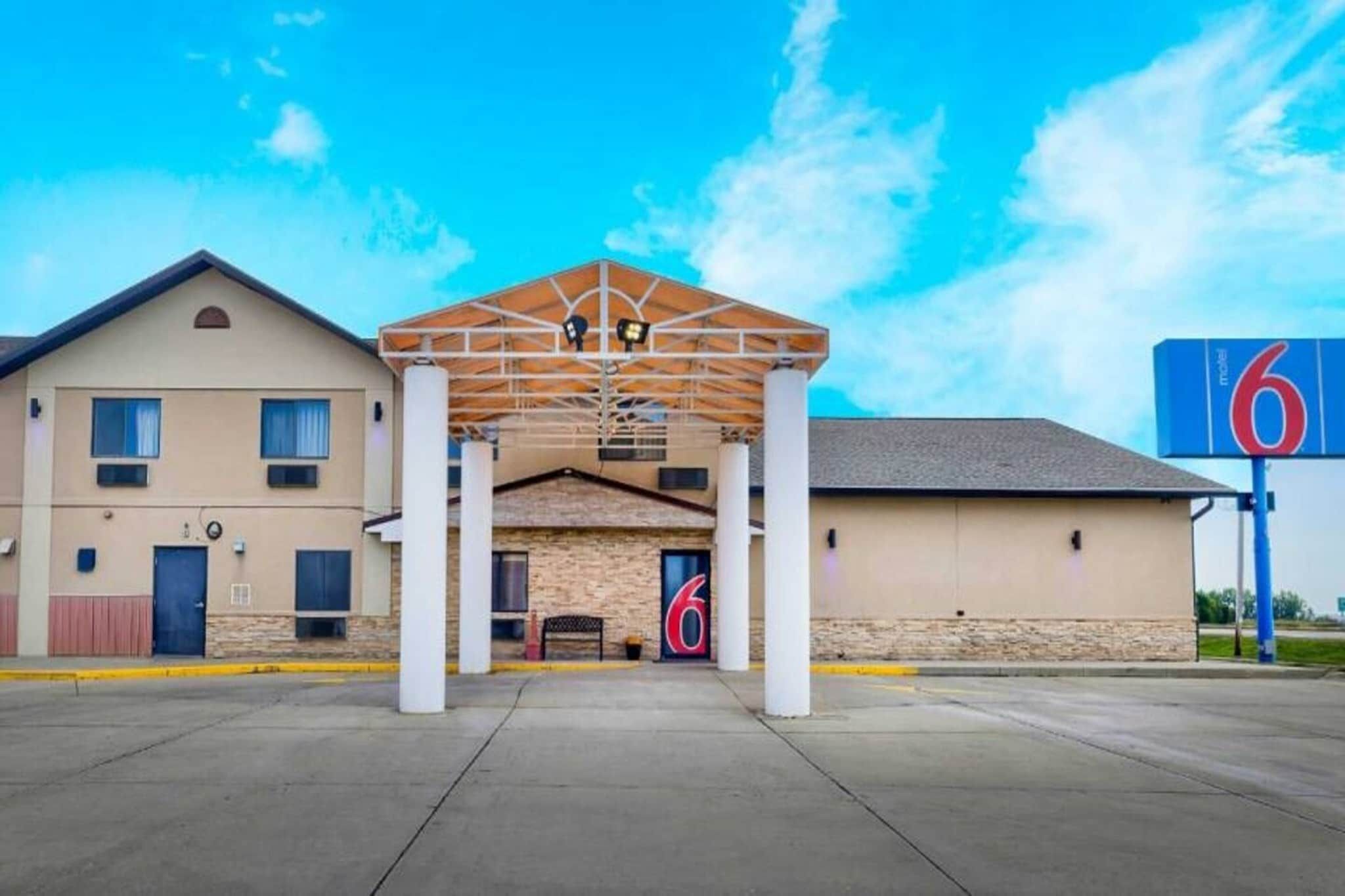 A motel with a covered entrance, a large '6' sign, and a parking lot.