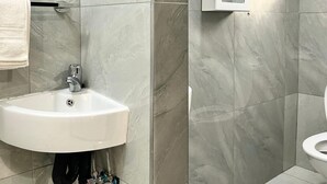 A bathroom with a white sink, a towel rack, and a toilet.