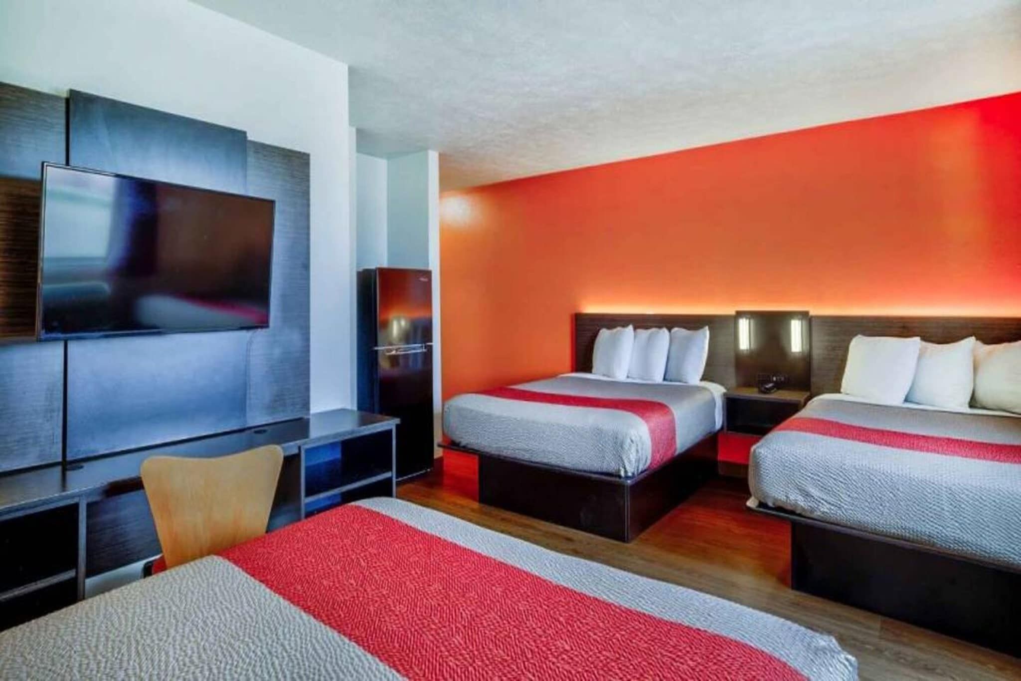 Une chambre d’hôtel avec un grand lit, un lit plus petit, une télévision et un bureau.