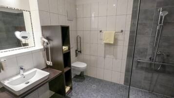 Un baño con lavabo, inodoro y zona de ducha.