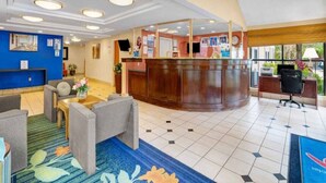 Eine Hotellobby mit einer Rezeption, einer Sitzecke und einem großen Fenster mit Blick.