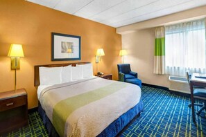 A hotel room with a bed, two bedside lamps, a chair, a desk with a laptop, and a window with curtains. - Sunny 1 Full Bed ADA|Free parking (MILFORD)