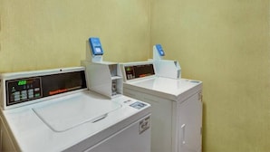 Ein Waschbereich mit zwei Waschmaschinen und Trocknern, jeweils mit digitaler Anzeige.