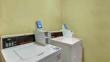 A laundry facility with two washing machines and dryers, each equipped with digital control panels.