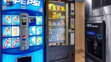 Máquina expendedora con logotipo de Pepsi, variedad de bocadillos y dispensador de Coca-Cola.