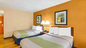 Ein Hotelzimmer mit zwei Betten, Holzboden und zwei Wandlampen.