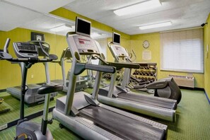 Una palestra con tapis roulant, ellittiche e una panca per pesi.
