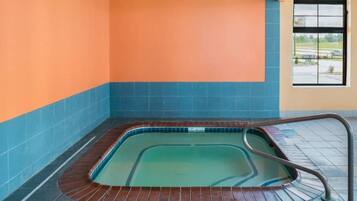 Una piscina con borde de azulejos y barandilla de metal.